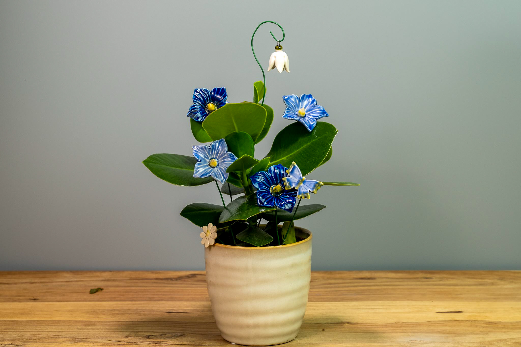 Keramikblumen neben einer lebenden Zimmerpflanze